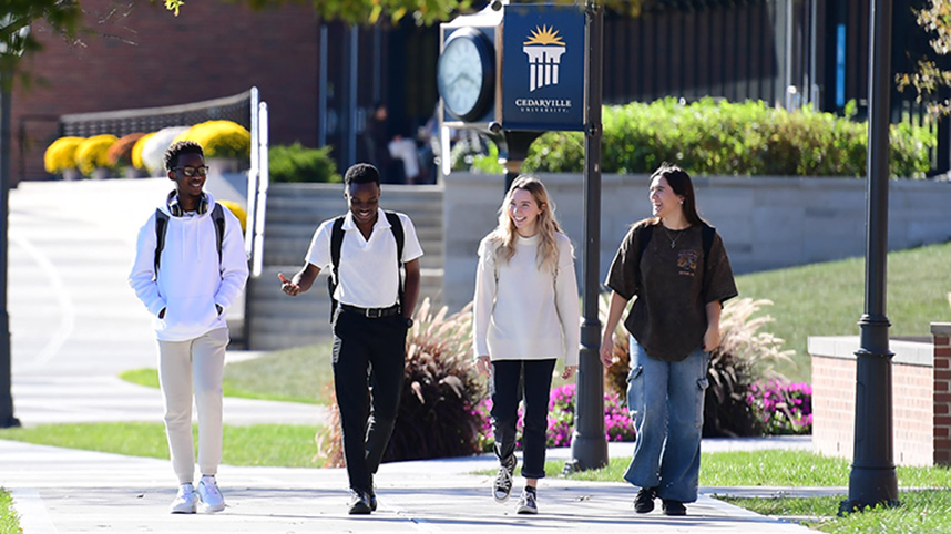Students walking along a sidewalk on the campus of Cedarville University.