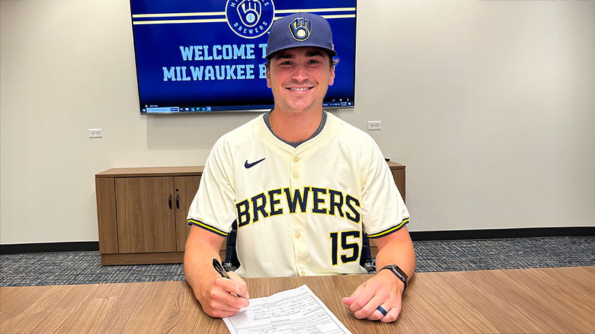 Tanner Gillis in a Milwaukee Brewers uniform as he signs with their organization.