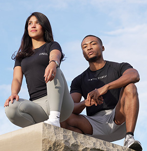 A male and female model, each wearing Temple Fitness clothing.