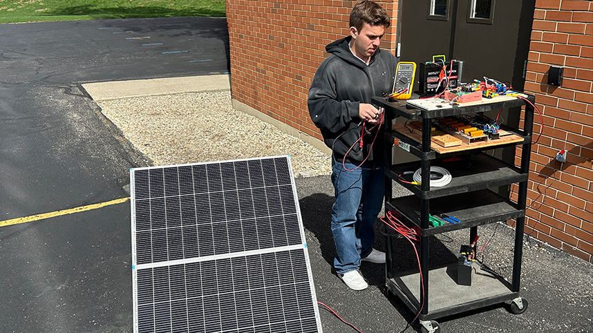 A young man working on  the solar controller he built for SonSet Solutions for use on the mission field.