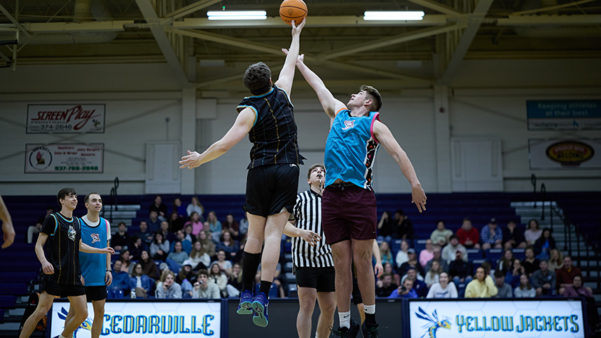 Two basketball players attempt to gain control of the ball at tip off.