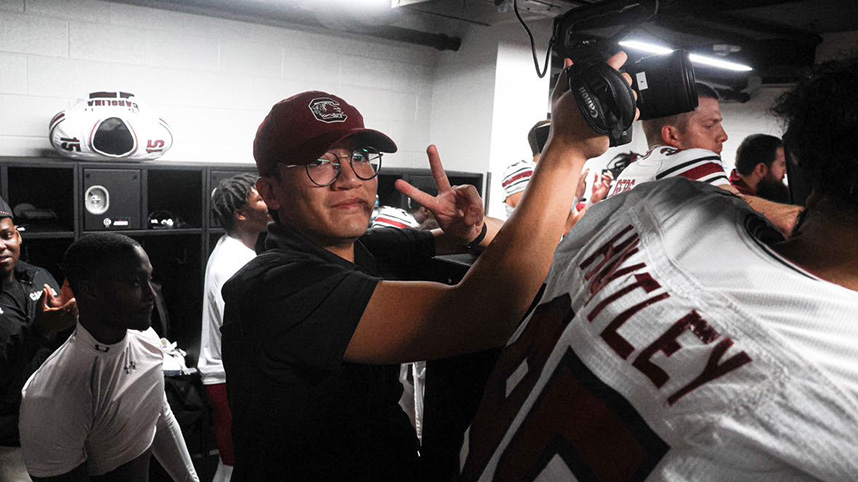 Ernest Toh filming in a football locker room.