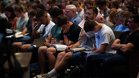 students opening bibles at fall bible conference