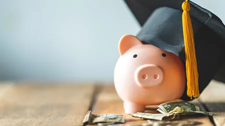 Piggy bank wearing a graduation cap symbolizing college savings and educational investment.