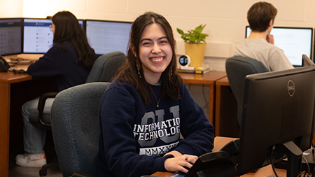 Information Technology Student Worker smiling at desk