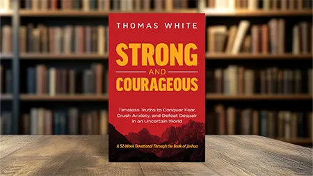 Book cover for Strong and Courageous on a table with book shelves in the background