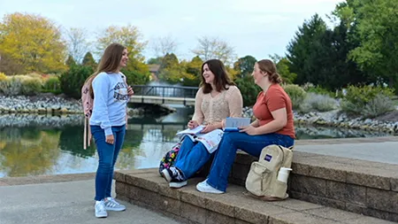 group of girls sitting on the steps and talking to each other