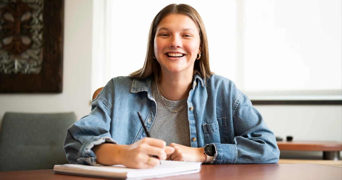 a female student writes on a notepad.