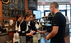 Barista serving customer coffee