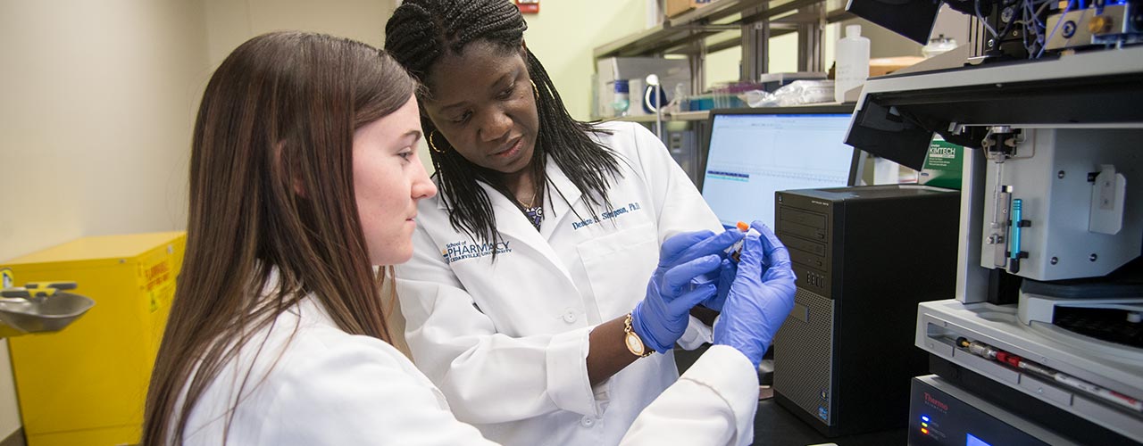 Female Pharmacy student observes a test tube