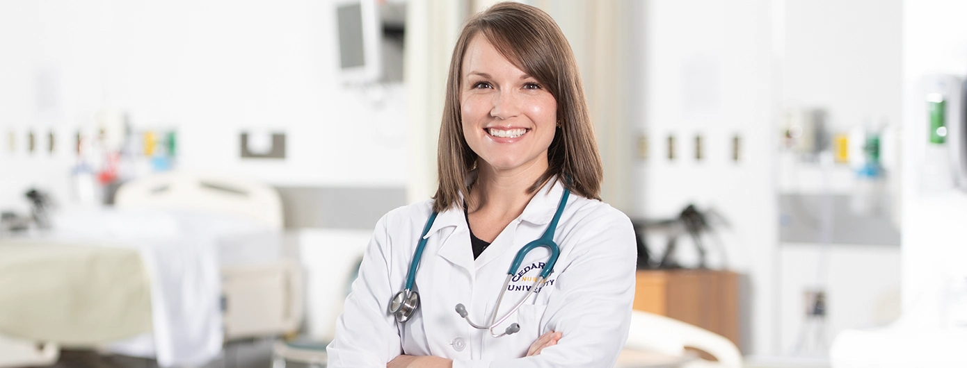 Female nurse wearing white lab coat and stethoscope in a hospital setting.