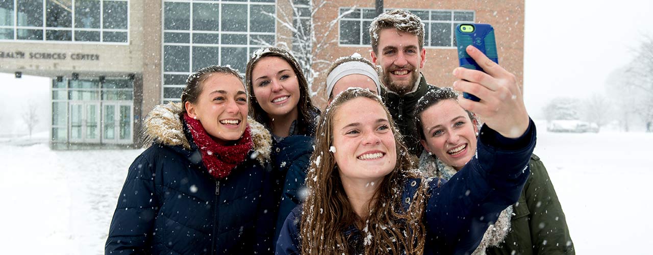 Students take a selfie in the snow outside the Health Sciences Center