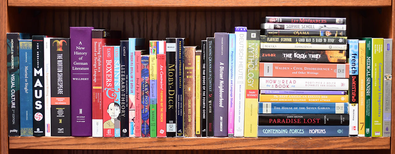 A bookshelf full of a random assortment of books.