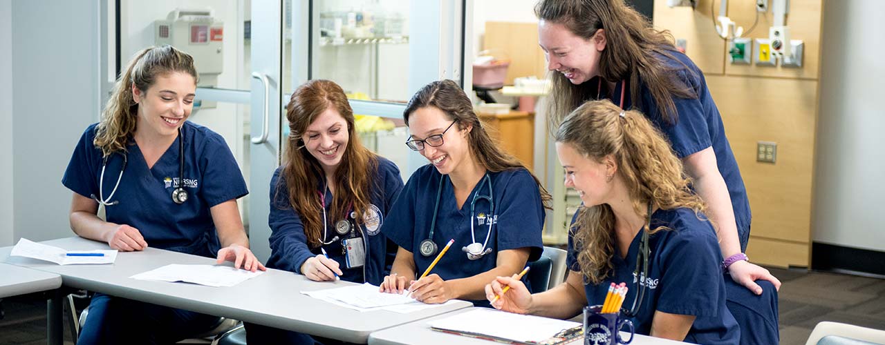 A group of female nursing students cheerfully collaborating