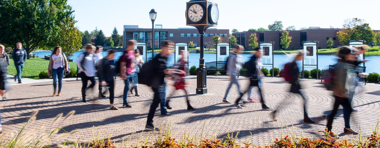 Rushing students walking by the clock outside of the SSC