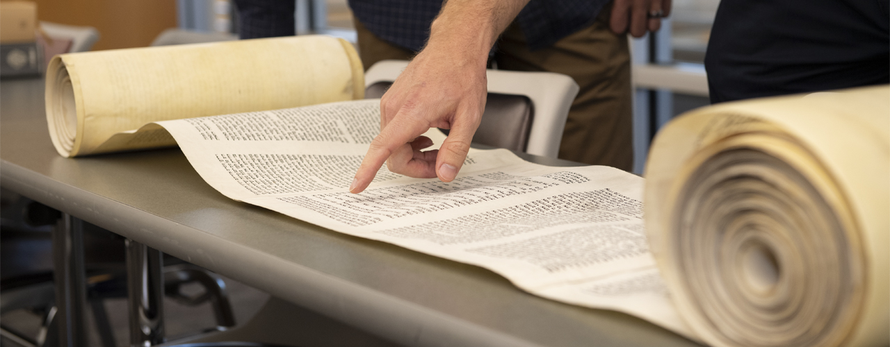 Image of Torah scroll partially rolled out on table