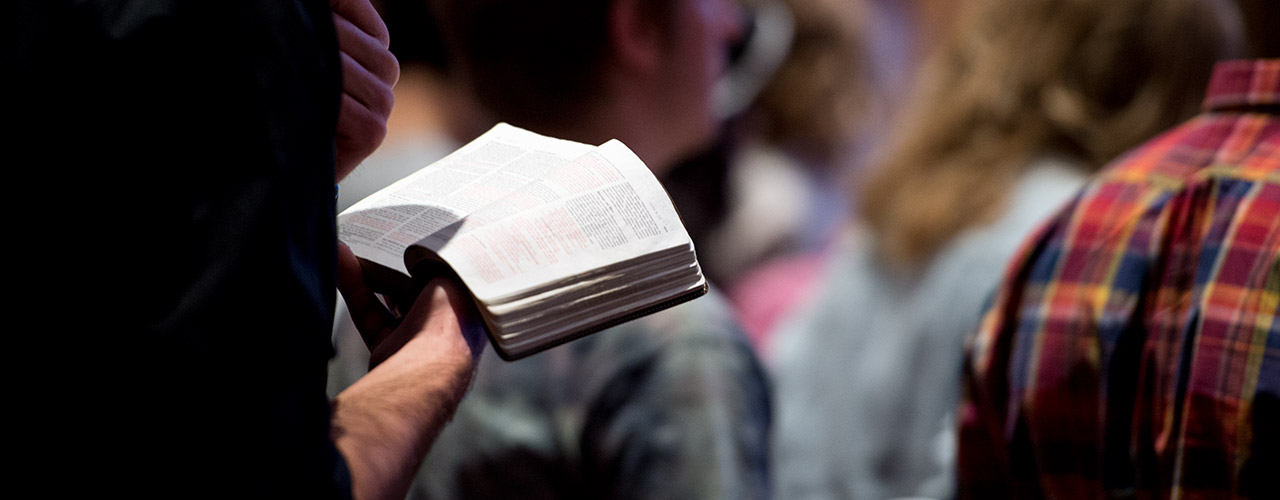 Male student reads from Bible during chapel