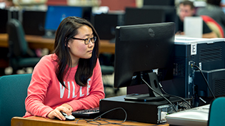 Female student using a computer in Cedarville's library