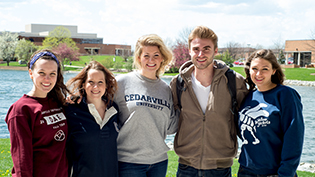 A group of mathematics alumni stand by Cedar Lake