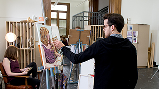 Male art student paints a portrait of a girl