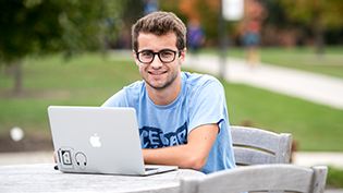 Male student using Apple laptop