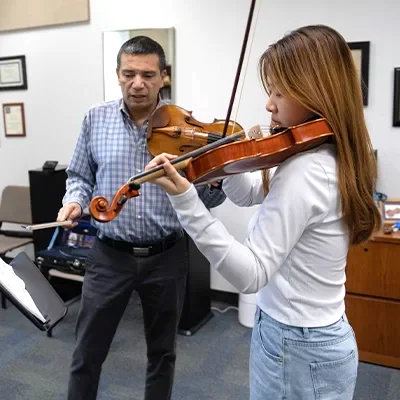 Professor and college student playing violins