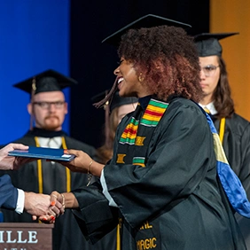 Female college graduate receiving diploma onstage