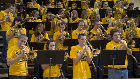 Large group of students playing instruments at basketball game