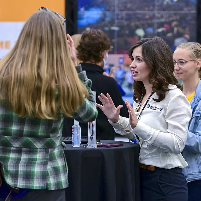 Cedarville admissions counselor speaking to a prospective student at an event.