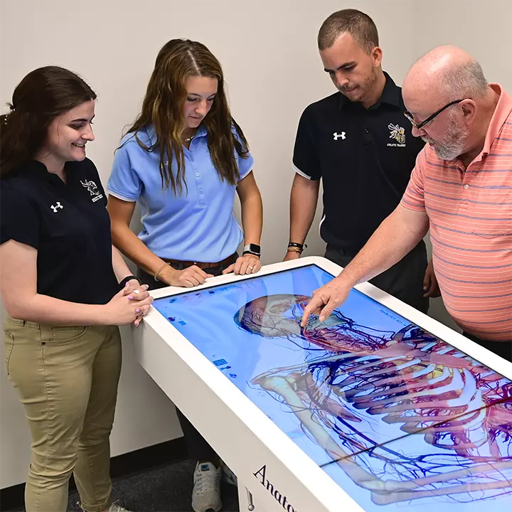 Faculty demonstrating anatomage table to students.