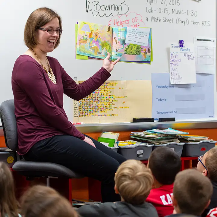 Woman teaching primary-aged children.